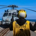 BM3 Sanaa Cooks signals to MH-60R Sea Hawk helicopter pilots