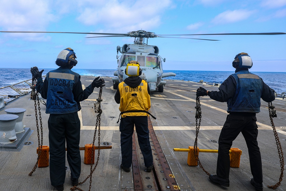 BM2 Jalynn Simmons, BM3 Sanaa Cooks and BM1 Jason Carpenter signal to MH-60R Sea Hawk helicopter pilots