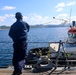 SN Samuel Ofori tosses a heaving line to an approaching tug boat