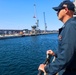 MA1 Cory Pilcher observes the waterfront for safe transit while docking