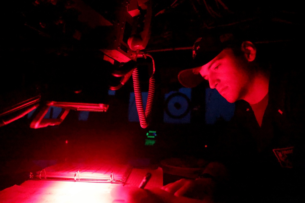 Ensign Luca Greenspun reviews night orders on the bridge
