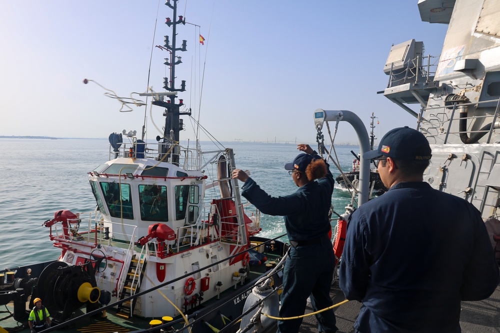 BM3 Sanaa Cooks throws a mooring ball and heaving line to an approaching tug boat