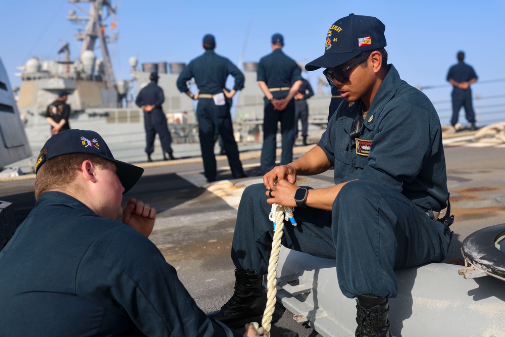 BM3 Collin Garey and BM3 Evandare Aganon splice an eye (loop) into a line while approaching pier side Naval Station Rota