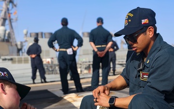 BM3 Collin Garey and BM3 Evandare Aganon splice an eye (loop) into a line while approaching pier side Naval Station Rota
