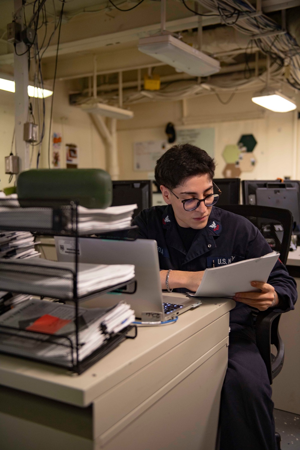 Nimitz Sailor Reads Through Paperwork