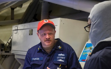 EM1 Kevin Parker conducts a damage control training debrief with crew members