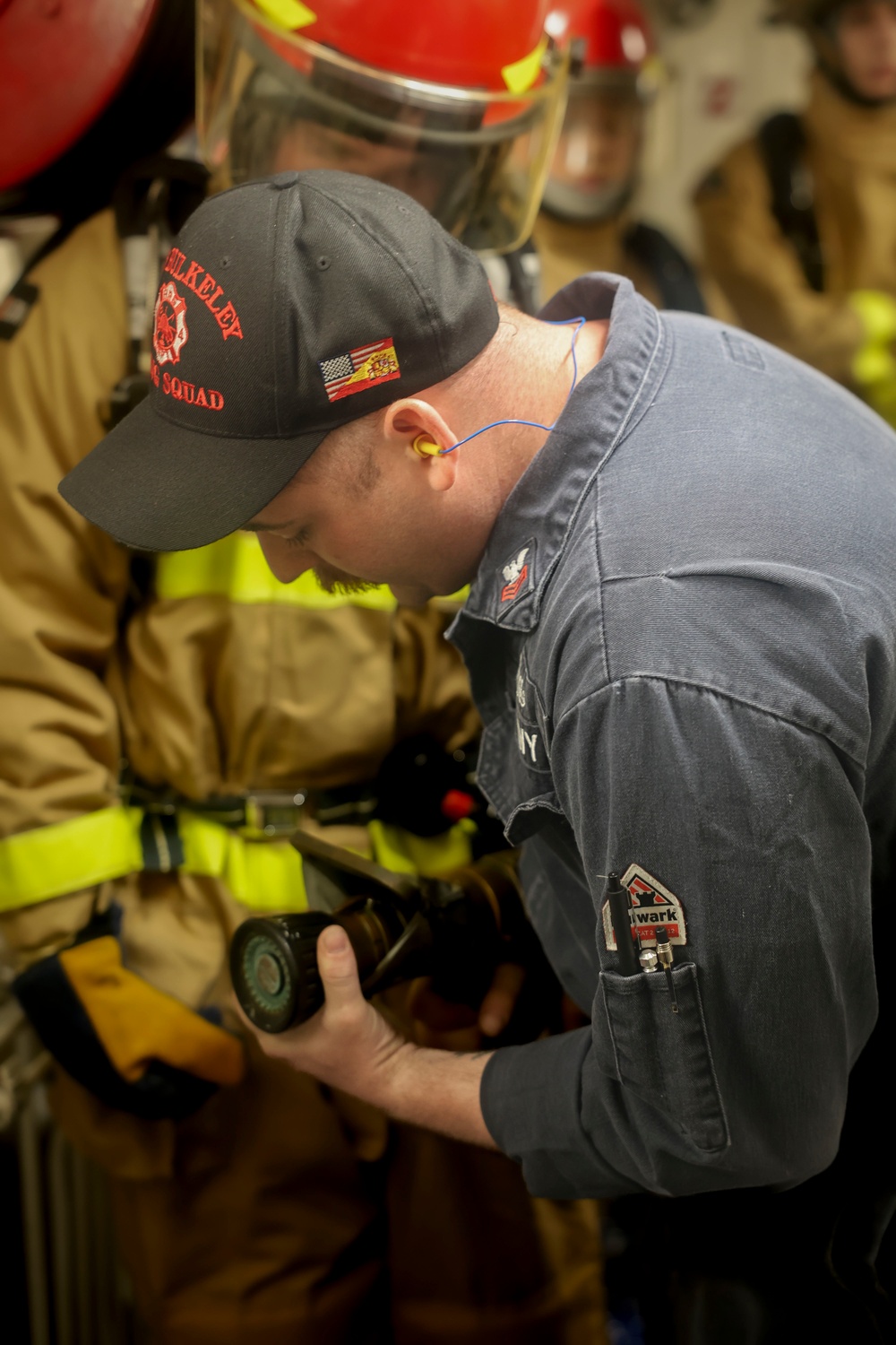 DC1 Cody Dormandy demonstrates the proper use of a firehose during a damage control general quarters