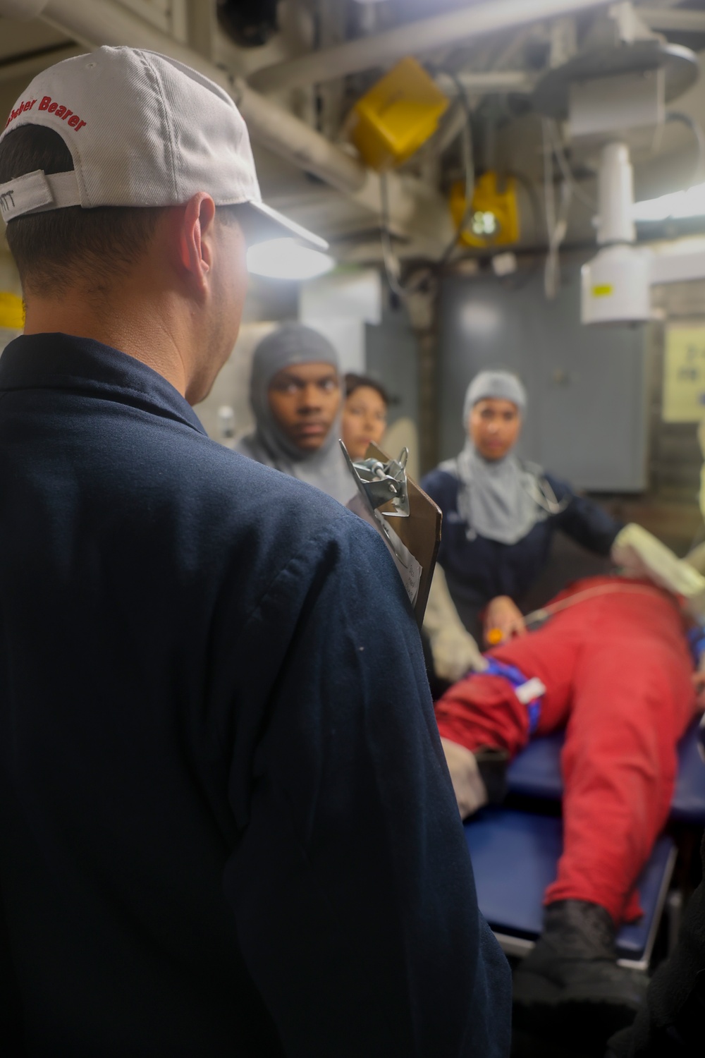 YN1 Joshua Kelley provides instruction to fellow crew members during a simulated medical casualty