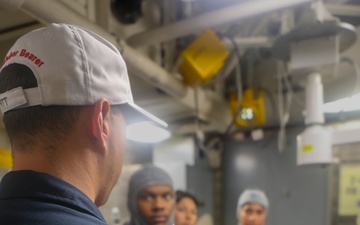 YN1 Joshua Kelley provides instruction to fellow crew members during a simulated medical casualty