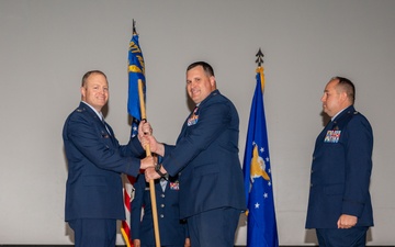 Lt. Col. Matthew Daniels, outgoing 377th Comptroller Squadron commander, passes the unit guidon to Col. Michael Power, 377th Air Base Wing and installation commander, during the 377th CPTS change of command ceremony
