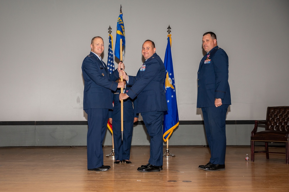 Lt. Col. James Denny, incoming 377th Comptroller Squadron commander, receives the unit guidon from Col. Michael Power, 377th Air Base Wing and installation commander