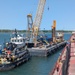 Hay Lake Marine Casualty responders move a barge with containment tanks into position