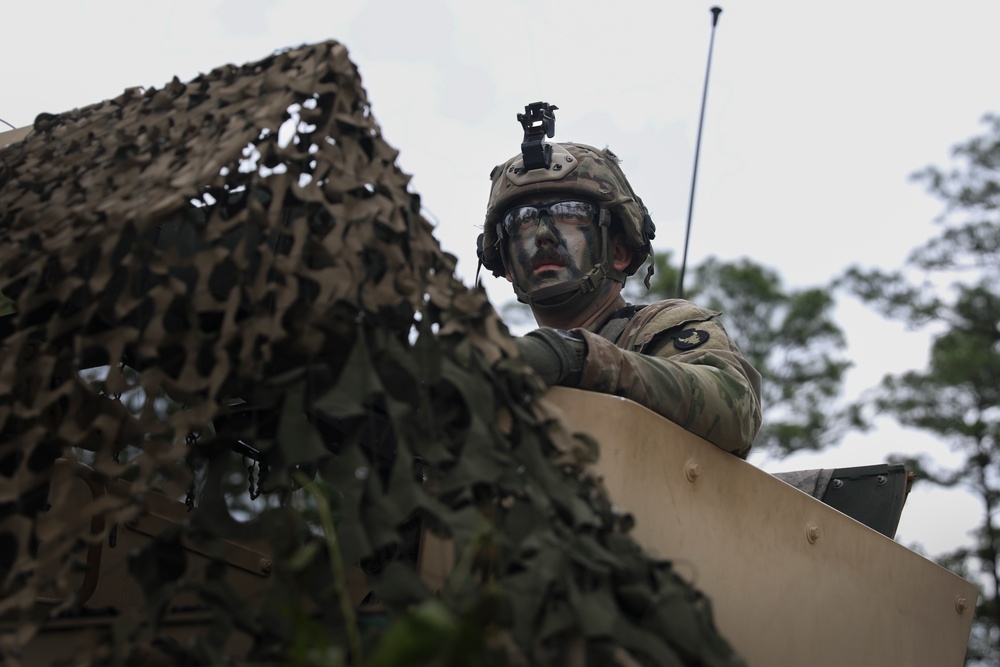 Iowa National Guard Soldier pulling security in camouflage at JRTC