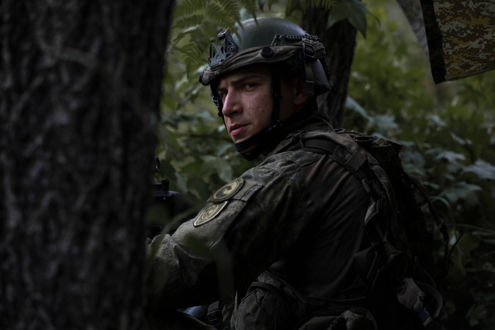 Kosovo Security Force soldier applies face paint during training at JRTC