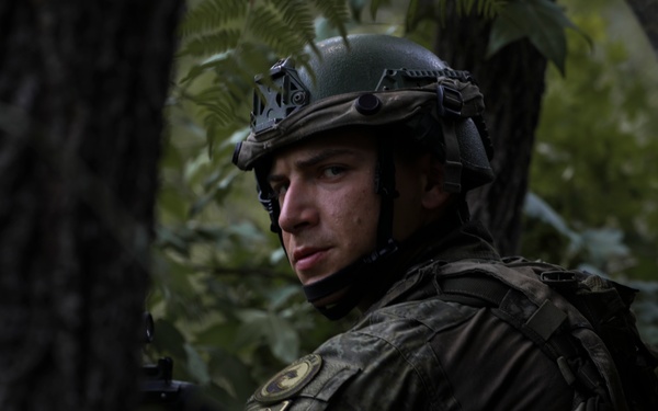 Kosovo Security Force soldier applies face paint during training at JRTC