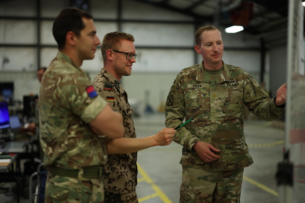 U.S. Army fire support officer talks with allied members during Warfighter 25-4