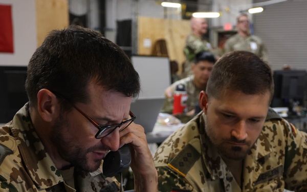 German Army liaison officer communicates by telephone with a colleague at the Main Command Post during Warfighter Exercise 25-4.