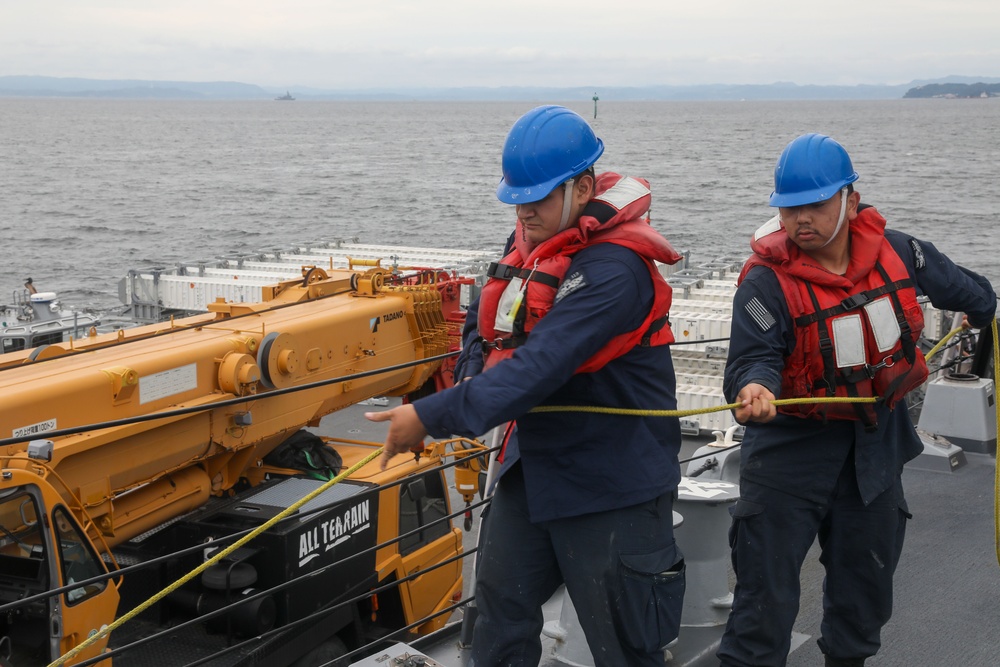 Sailors aboard the USS John Finn conduct an ammo onload in Yokosuka, Japan