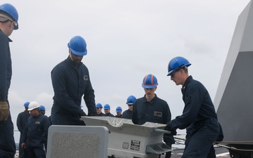 Sailors aboard the USS John Finn conduct an ammo onload in Yokosuka, Japan