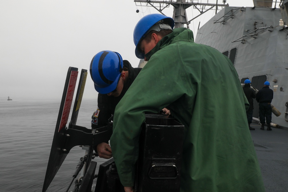 Sailors aboard the USS John Finn conduct an ammo onload in Yokosuka, Japan