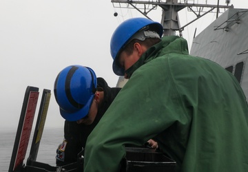 Sailors aboard the USS John Finn conduct an ammo onload in Yokosuka, Japan
