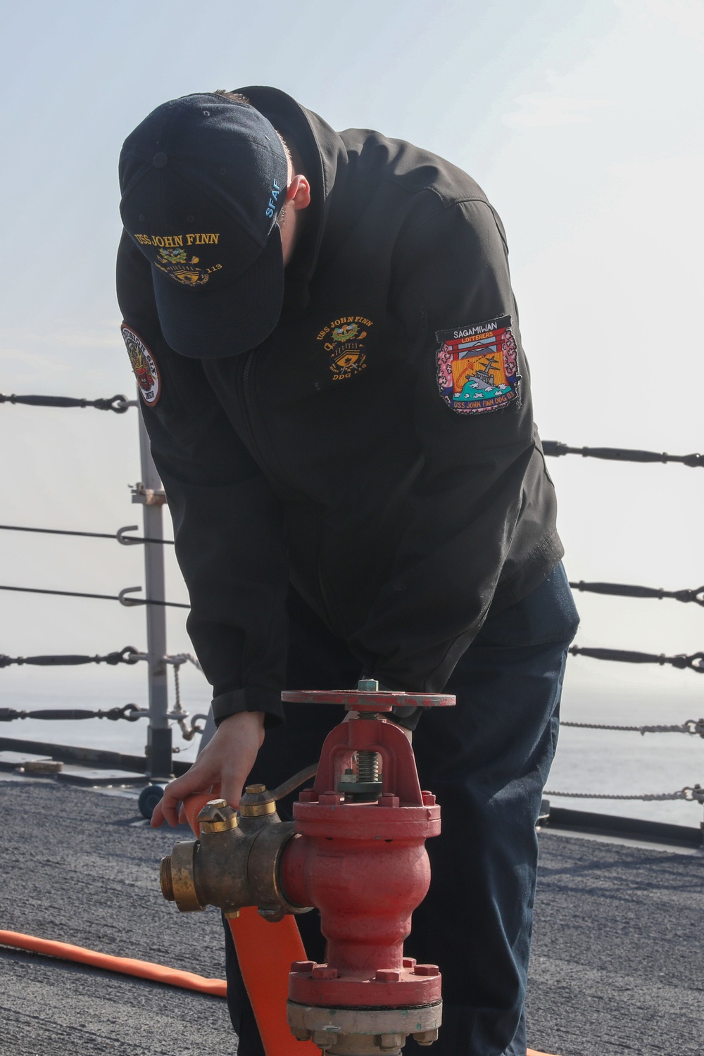Sailors aboard the USS John Finn conduct a sea and anchor detail in Yokosuka, Japan