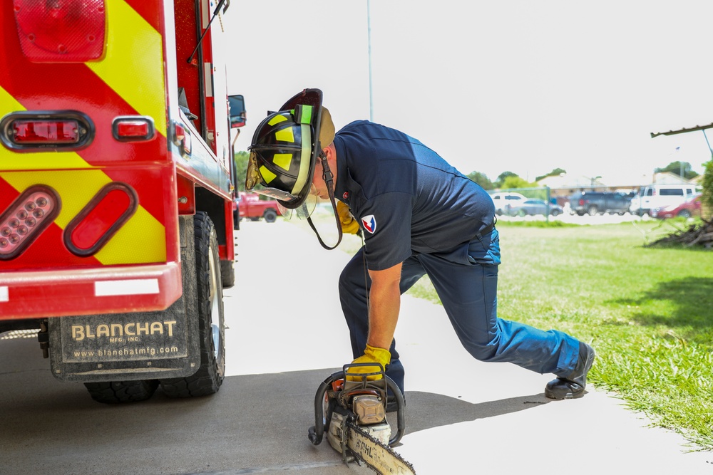 Firefighter Adam Burkholder cranks chainsaw to test operations