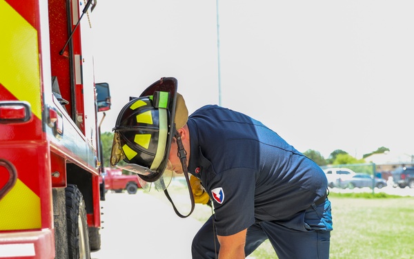 Firefighter Adam Burkholder cranks chainsaw to test operations