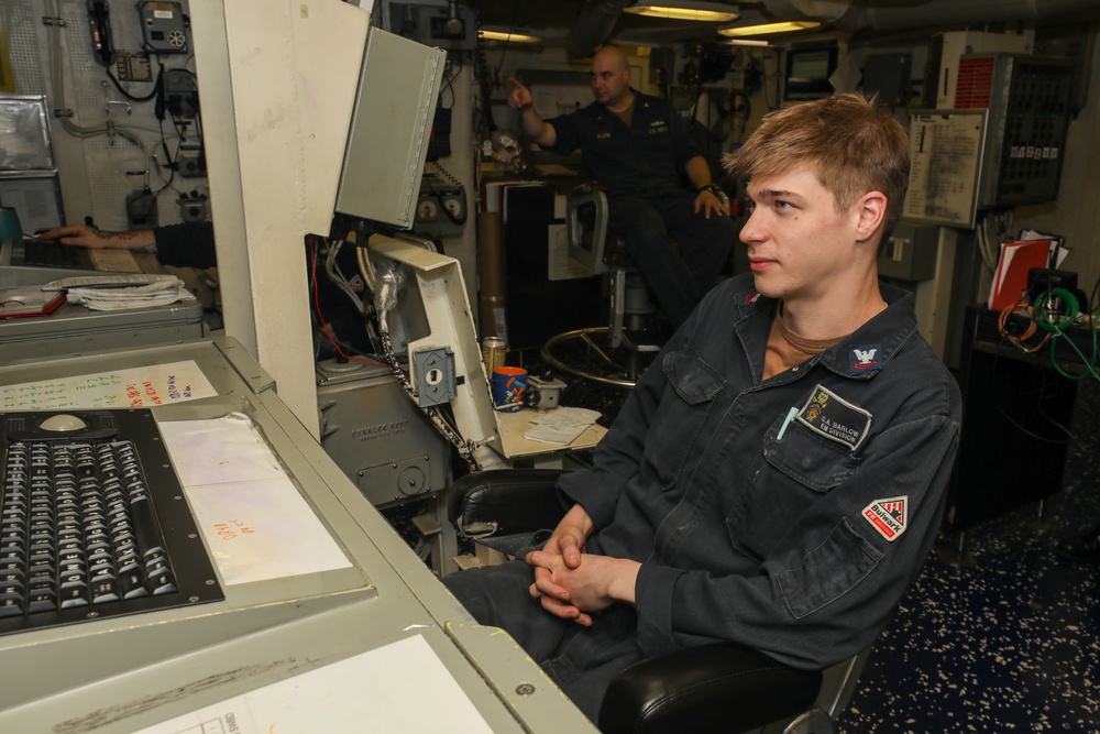 Sailors aboard the USS John Finn conduct watch in front of the Electric Plant Control Console in the Philippine Sea