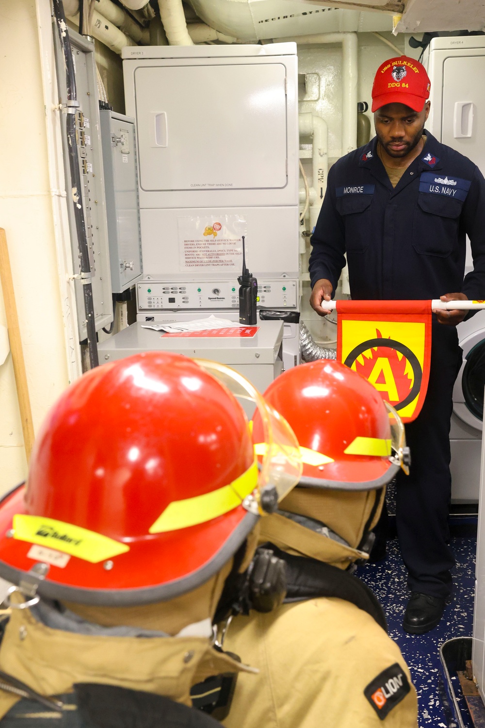 DC1 Anthony Monroe posts with a signal flag during a damage control training