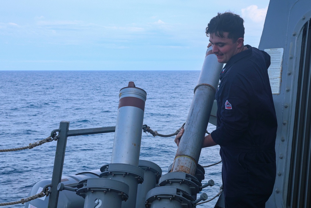 CTT2 Thomas Kerr loads a MK214 chaff round