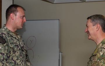 CJCS Gen. Caine greets and presents coins U.S. Africa Command team members