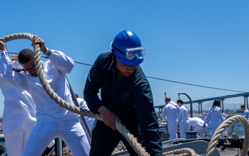 USS PEARL HARBOR (LSD 52) Sailors man the rails as the ship departs for Pacific Partnership 2025