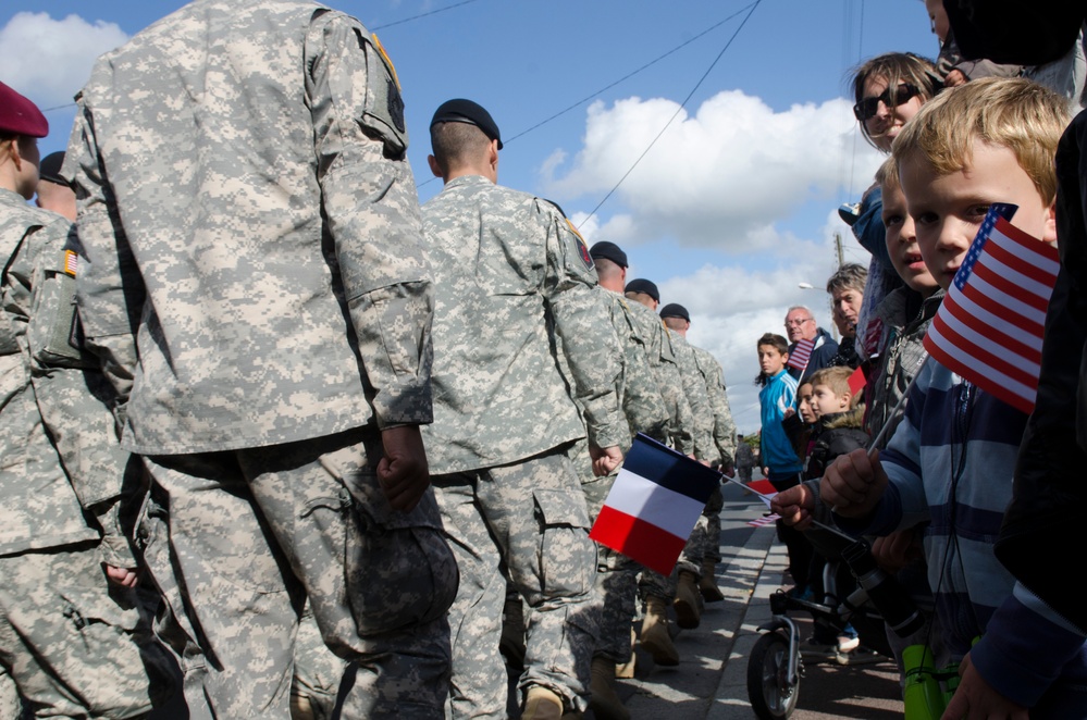 Allied Troops Parade Through Carentan, France as Citizens Wave Flags