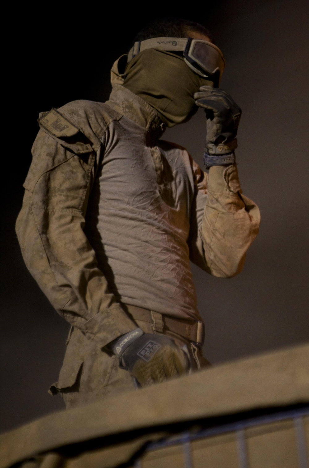 Marine Combat Engineer Braces Against Sand While Filling HESCO Barriers in Afghanistan