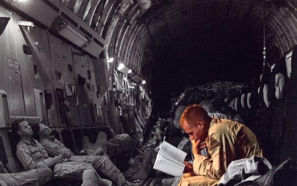 Service Member Reads During Long Military Flight