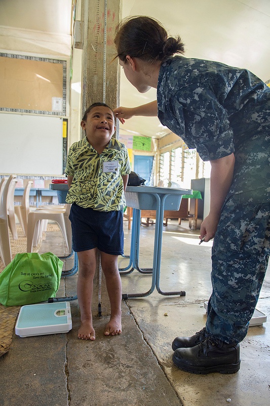 Navy Sailor Measures Child's Height for Samoan Special Olympics