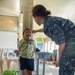 Navy Sailor Measures Child's Height for Samoan Special Olympics