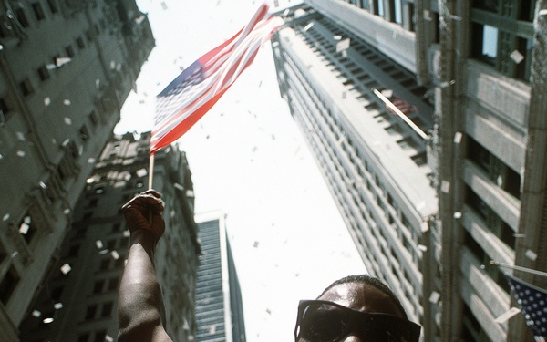 Triumphant Homecoming: Soldier Waves Flag at Desert Storm Victory Parade