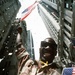 Triumphant Homecoming: Soldier Waves Flag at Desert Storm Victory Parade