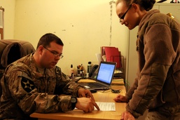 Air Force Tech. Sgt. Explains In-Processing to Visiting Service Member in Afghanistan