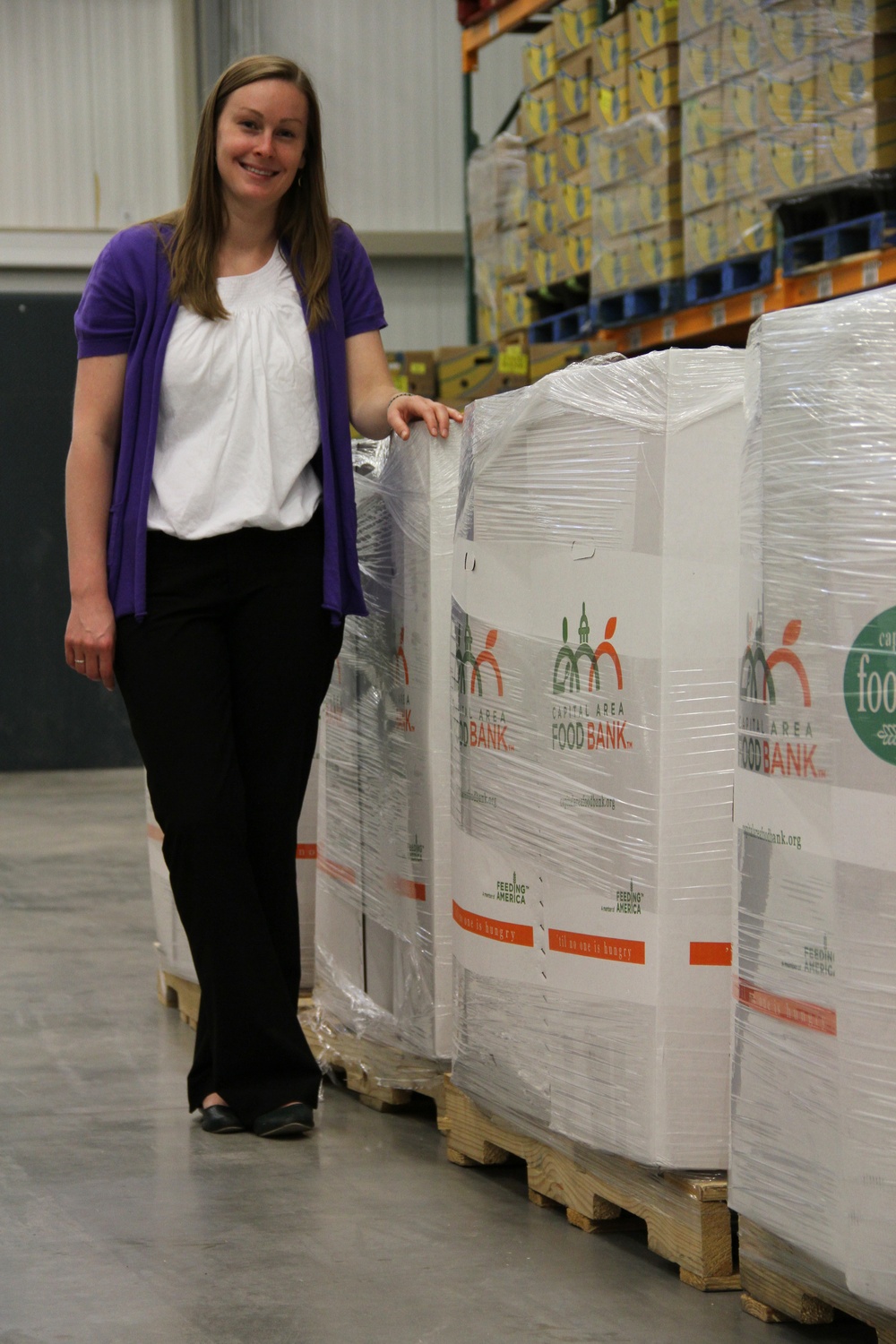 Food Bank Coordinator Poses with Donated Goods