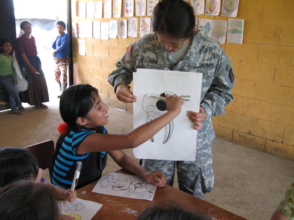 U.S. Army Captain Teaches Guatemalan Girl Dental Hygiene During Medical Training Exercise