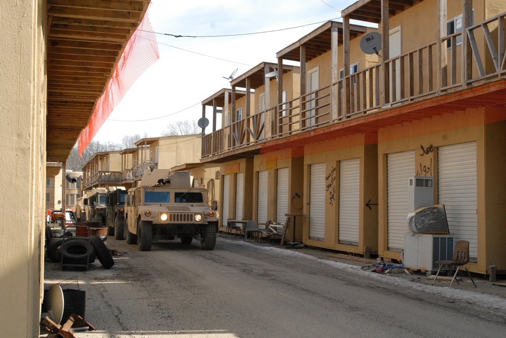 Convoy Navigates Mock Alleyway in Realistic Urban Training Exercise