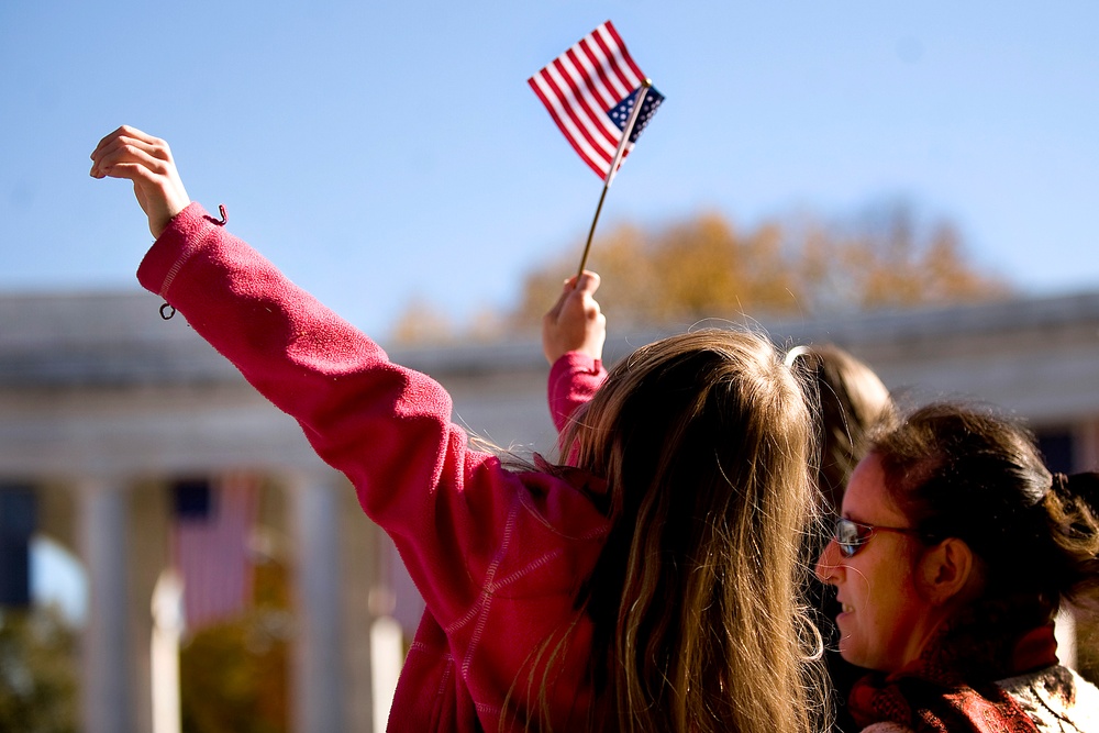Girl Waves Flag at Veterans Day Ceremony in Arlington