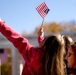 Girl Waves Flag at Veterans Day Ceremony in Arlington