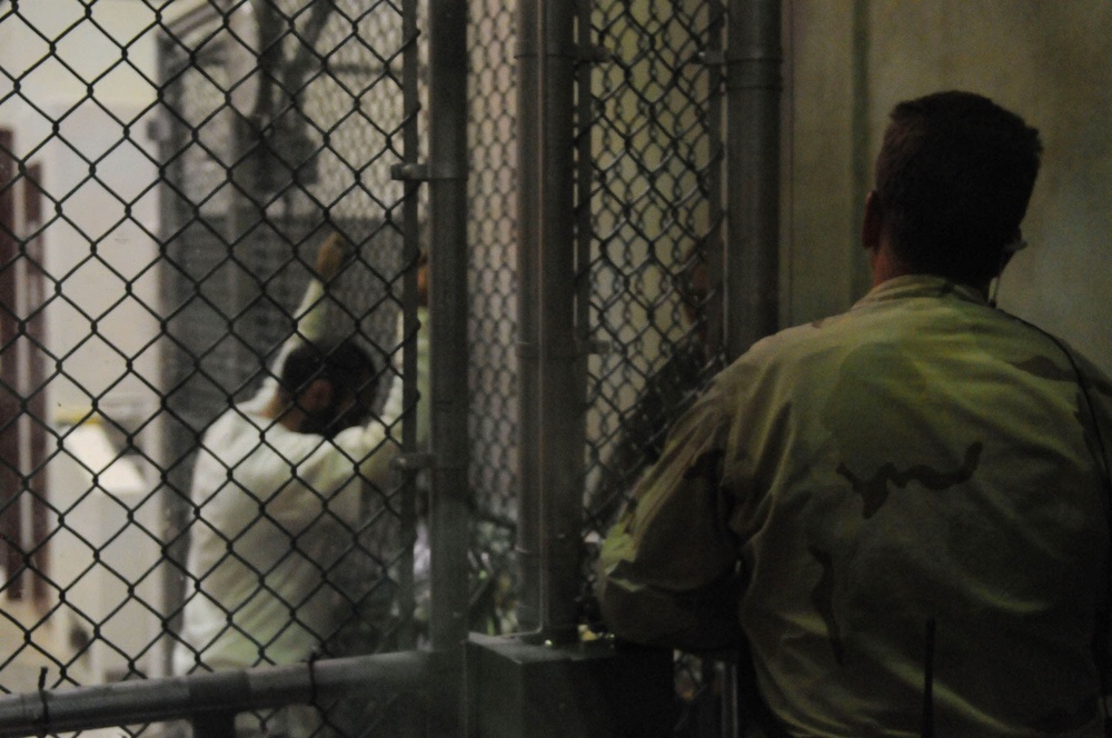 Sailor Stands Guard Over Detainees Reading in Guantanamo Bay Camp 6
