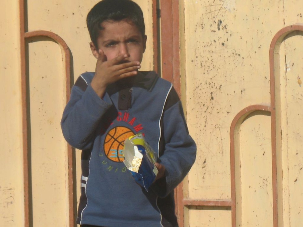 Iraqi Boy Enjoys Popcorn from U.S. Soldiers During Polling Site Reconnaissance