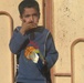 Iraqi Boy Enjoys Popcorn from U.S. Soldiers During Polling Site Reconnaissance