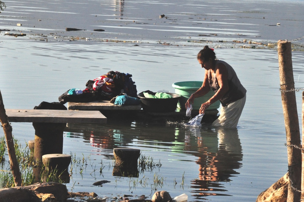 Salvadoran Woman Washes Clothes in Flood-Affected Lake